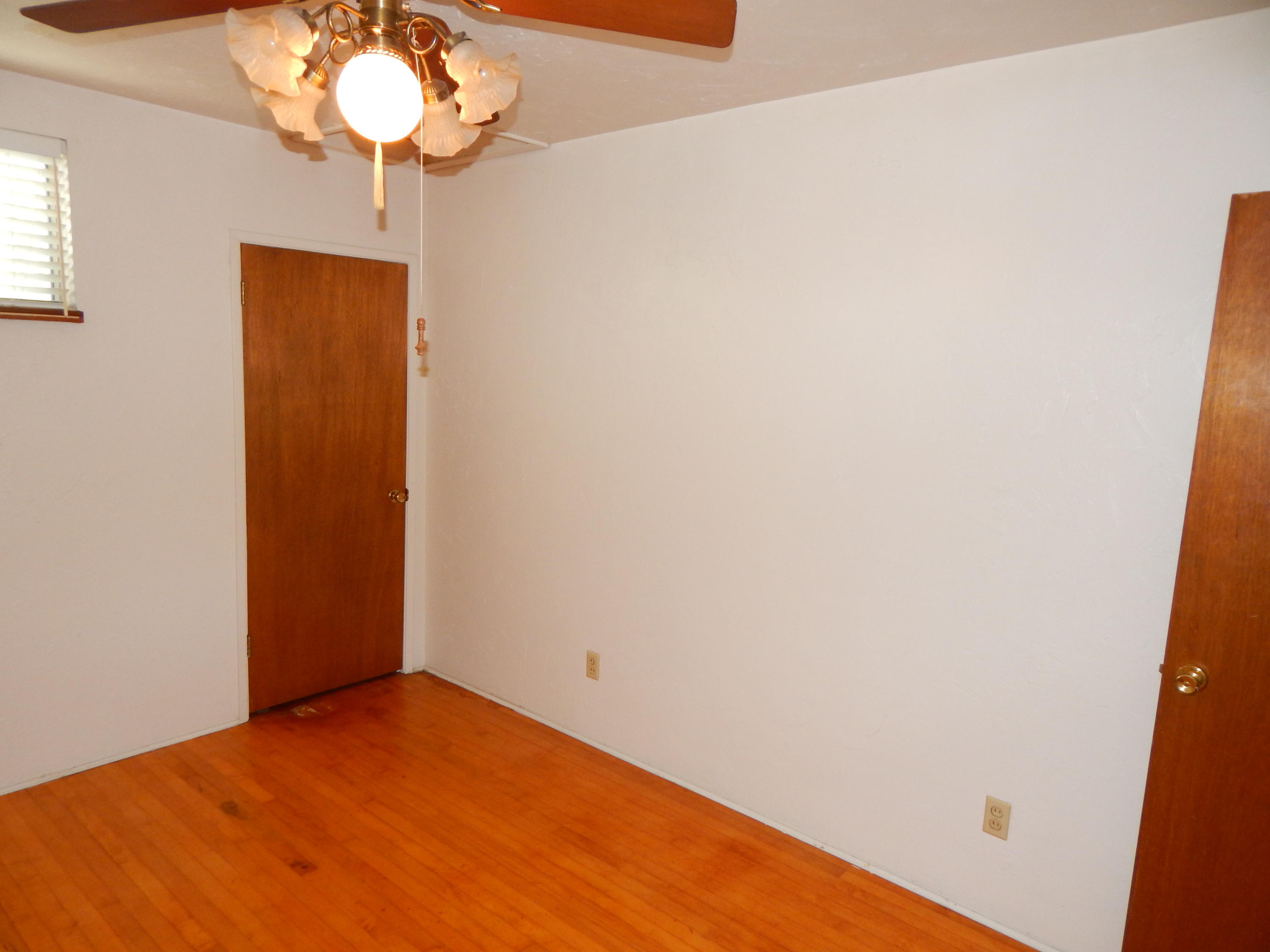 6460 Riverside Drive Redding, CA 96001 - Photo 47 of 81 an empty room with a chandelier fan and wooden floor
