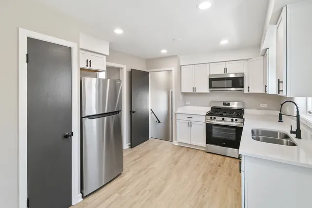 a kitchen with stainless steel appliances granite countertop a refrigerator stove and sink
