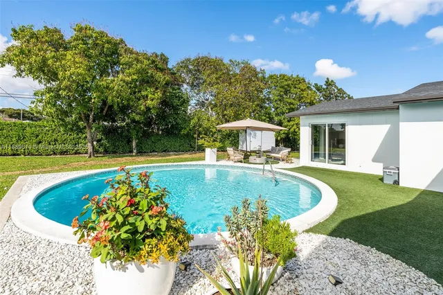 a swimming pool with outdoor seating and yard