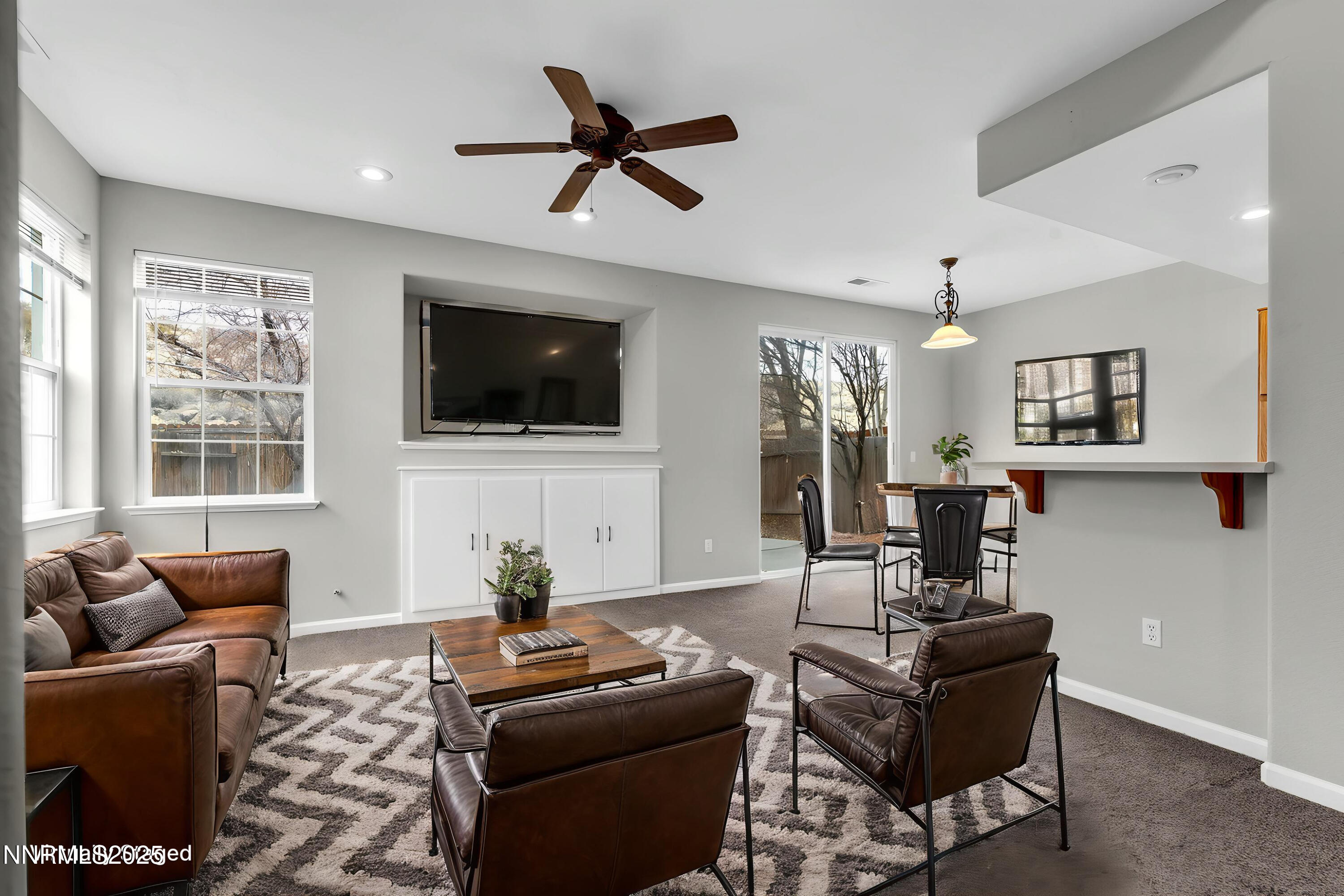 a living room with furniture a flat screen tv and a window