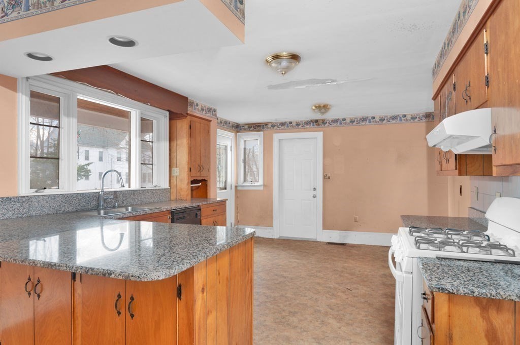 37 School Street Merrimac, MA 01860 - Photo 7 of 34 a kitchen with granite countertop a sink a stove and cabinets