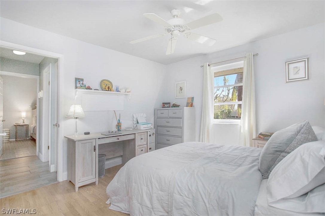 1447 Albatross Road Sanibel, FL 33957 - Photo 17 of 29 a bedroom with a bed and a chandelier
