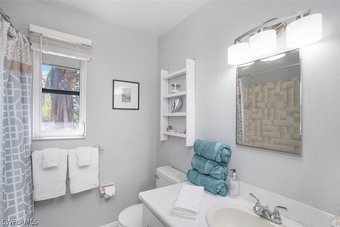 1447 Albatross Road Sanibel, FL 33957 - Photo 18 of 29 a bathroom with a sink and mirror with toilet