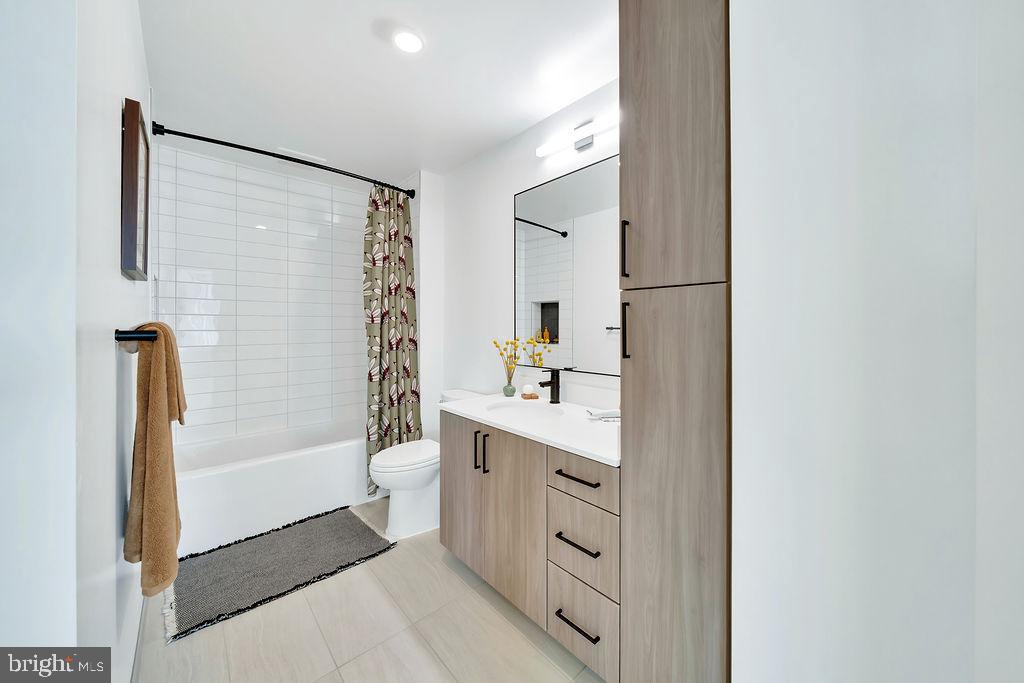 113 Potomac Avenue Southwest, Unit 401 Washington, DC 20024 - Photo 17 of 50 a bathroom with a bathtub sink mirror and a shower