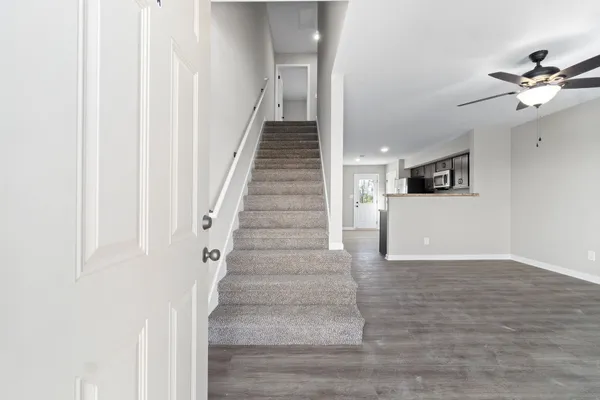 a view of a hallway with wooden floor and entryway