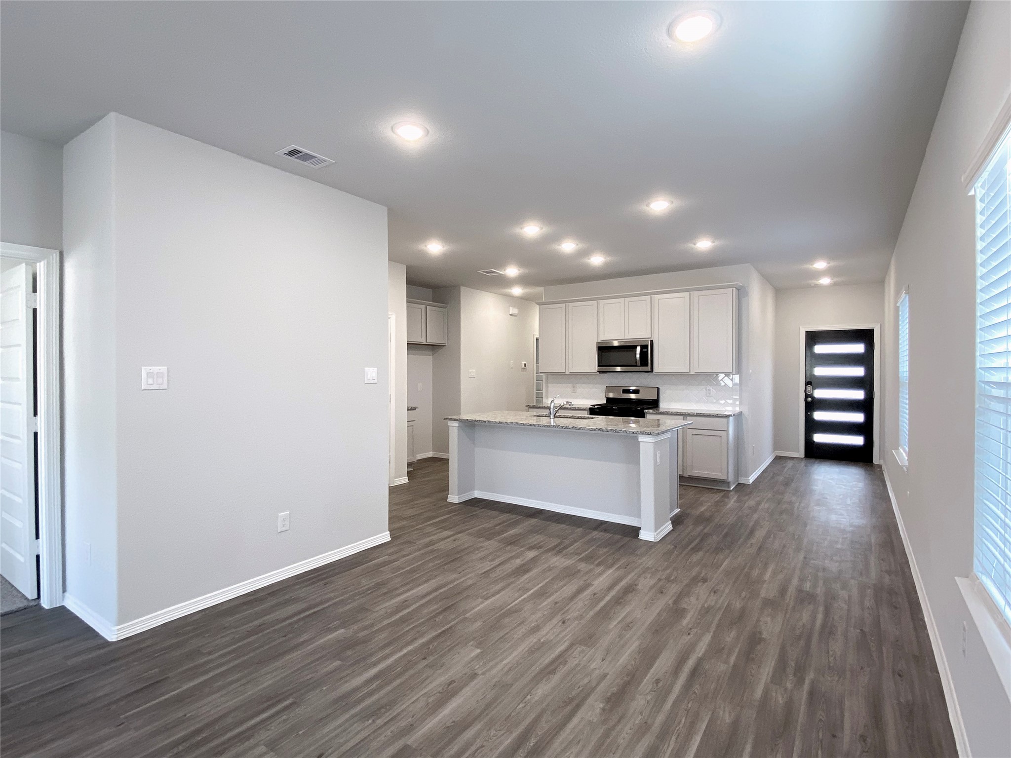 23338 Spring Genesis Lane Katy, TX 77493 - Photo 8 of 18 Luxury vinyl floor in the foyer, kitchen and family room, easy to maintain