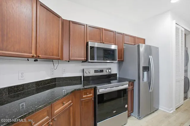 a kitchen with stainless steel appliances granite countertop a refrigerator stove and microwave