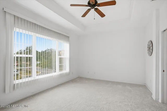 a view of a room with a window and a ceiling fan
