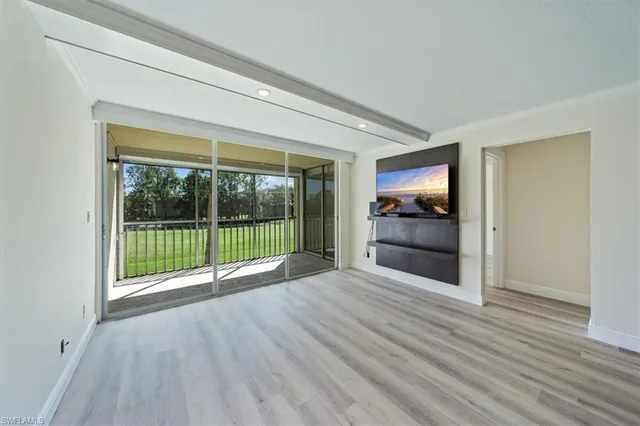 a view of empty room with wooden floor and fireplace