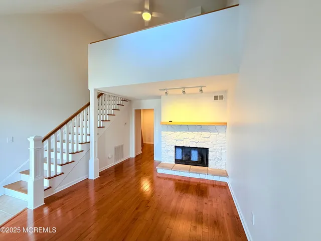 a view of an empty room with a fireplace and wooden floor