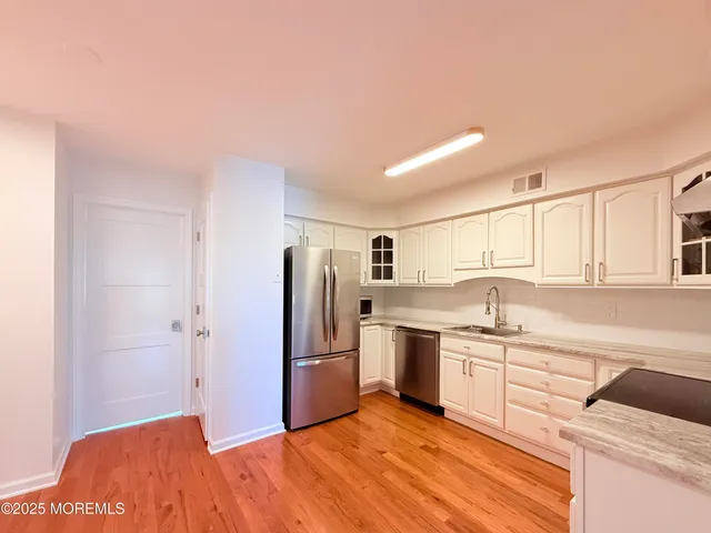 a kitchen with a sink stainless steel appliances and cabinets