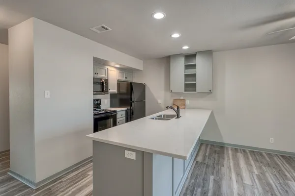 a kitchen with stainless steel appliances granite countertop a sink stove and refrigerator