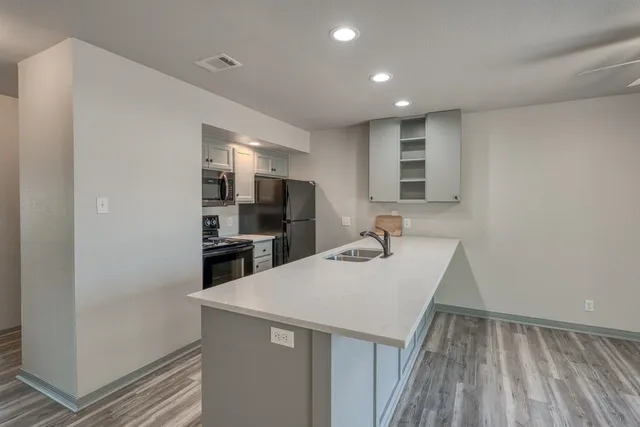a kitchen with stainless steel appliances granite countertop a sink stove and refrigerator