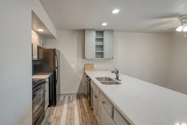 an empty room with wooden floor and fan