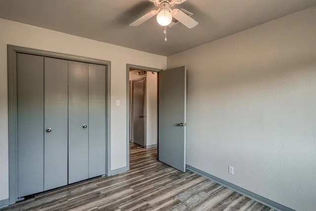 an empty room with a window and a fan