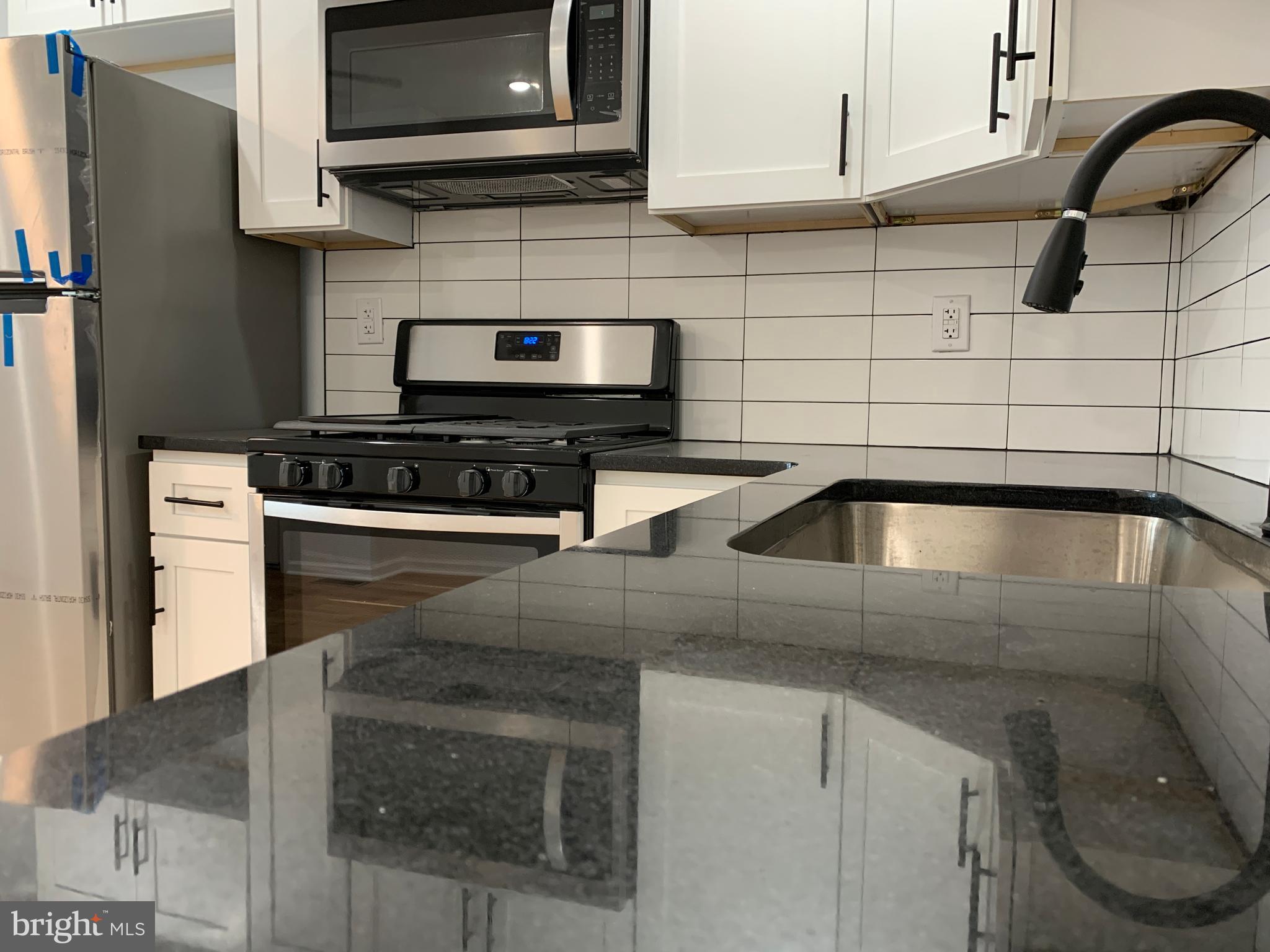 431 South 56th Street, Unit 1 Philadelphia, PA 19143 - Photo 11 of 29 a kitchen with stainless steel appliances granite countertop a sink and a stove