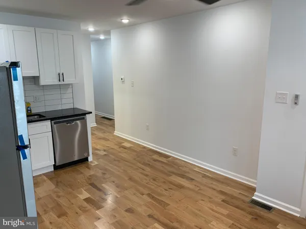 a view of kitchen with wooden floor and electronic appliances