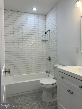 a bathroom with a white toilet a sink and bathtub