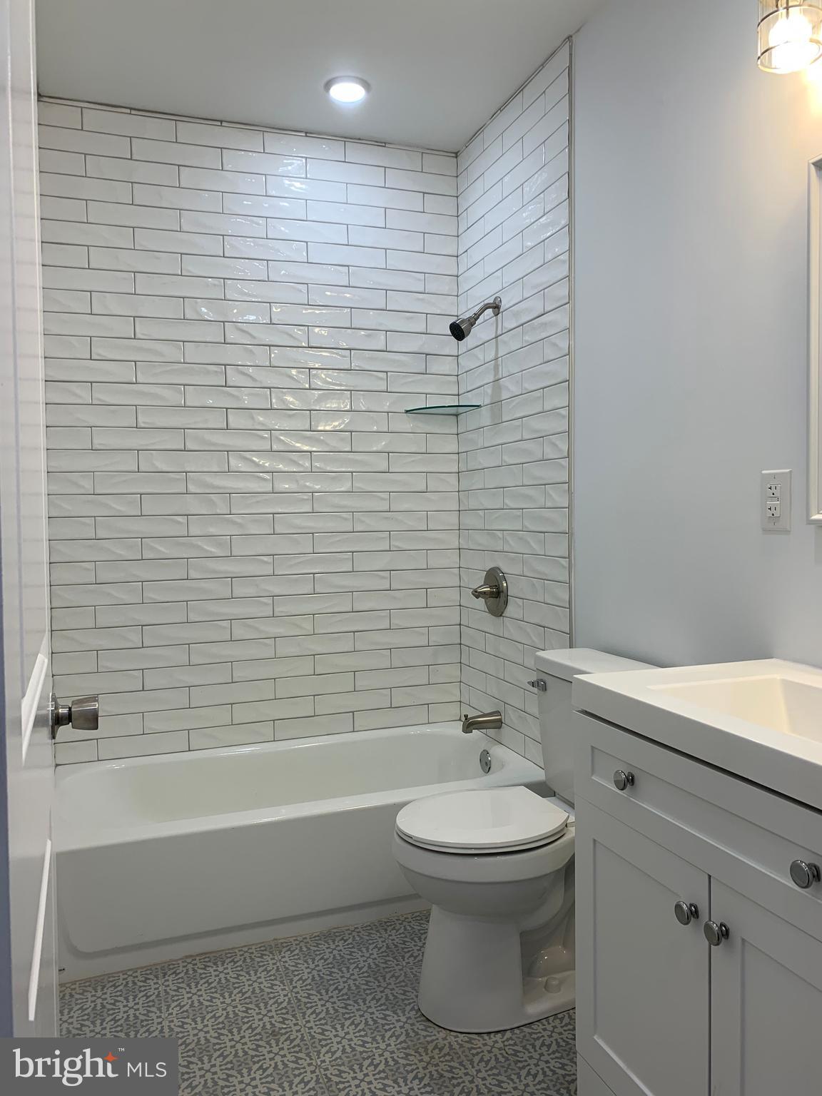 431 South 56th Street, Unit 1 Philadelphia, PA 19143 - Photo 18 of 29 a bathroom with a white toilet a sink and bathtub