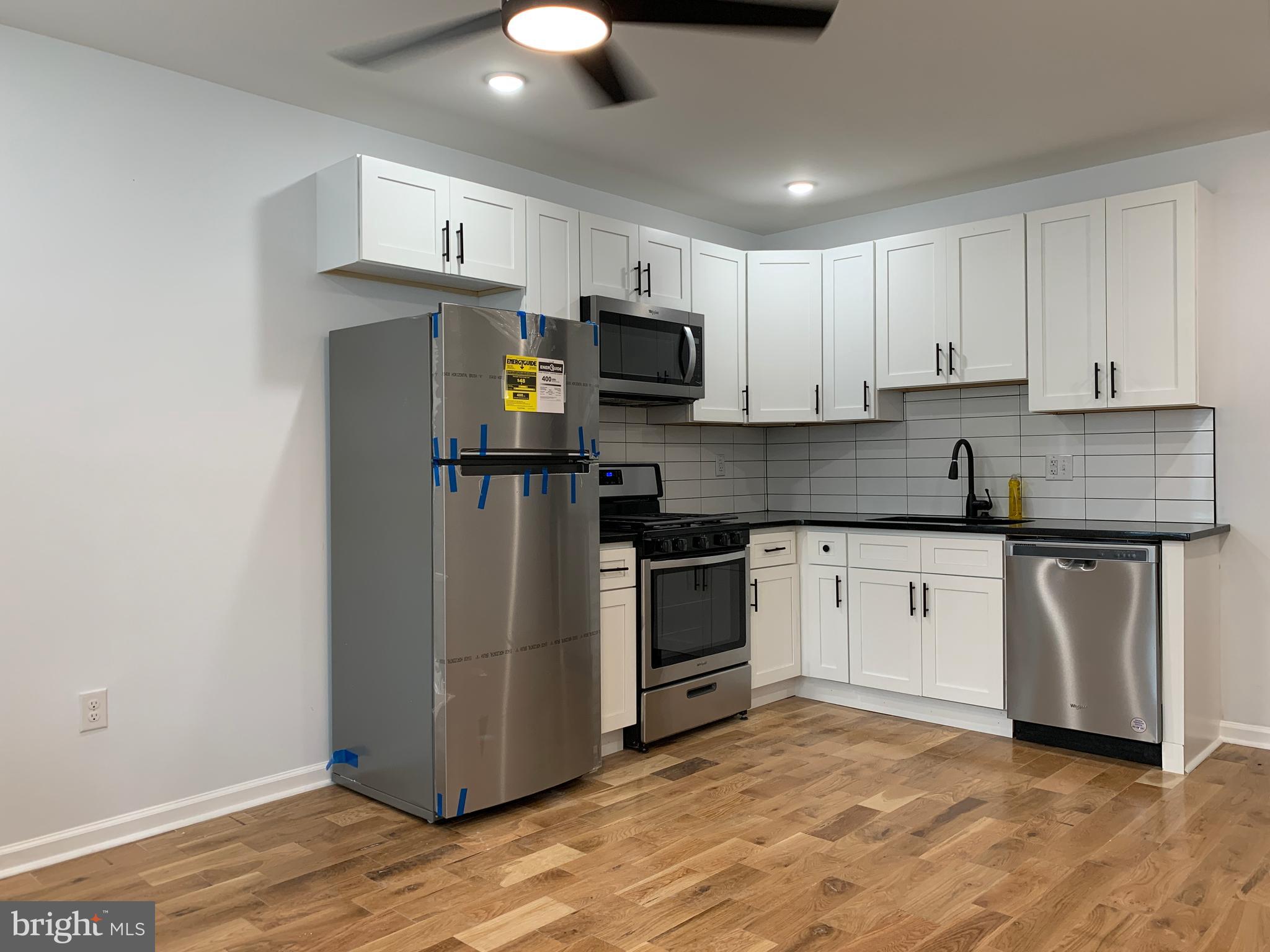 431 South 56th Street, Unit 1 Philadelphia, PA 19143 - Photo 3 of 29 a kitchen with stainless steel appliances granite countertop a stove a sink and a refrigerator