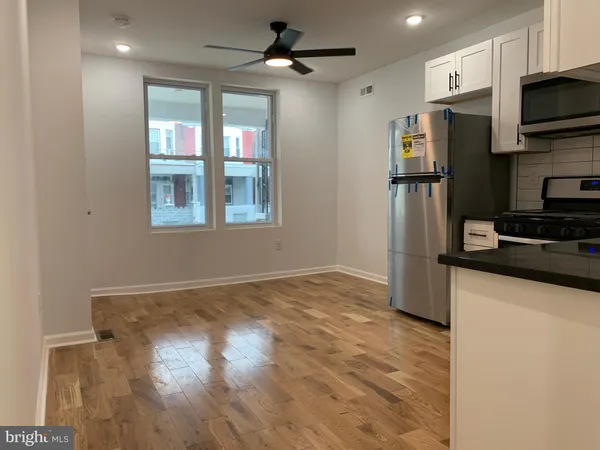 a kitchen with granite countertop a refrigerator and a stove top oven