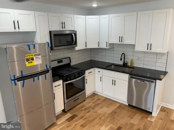 a kitchen with granite countertop a sink a stove and cabinets