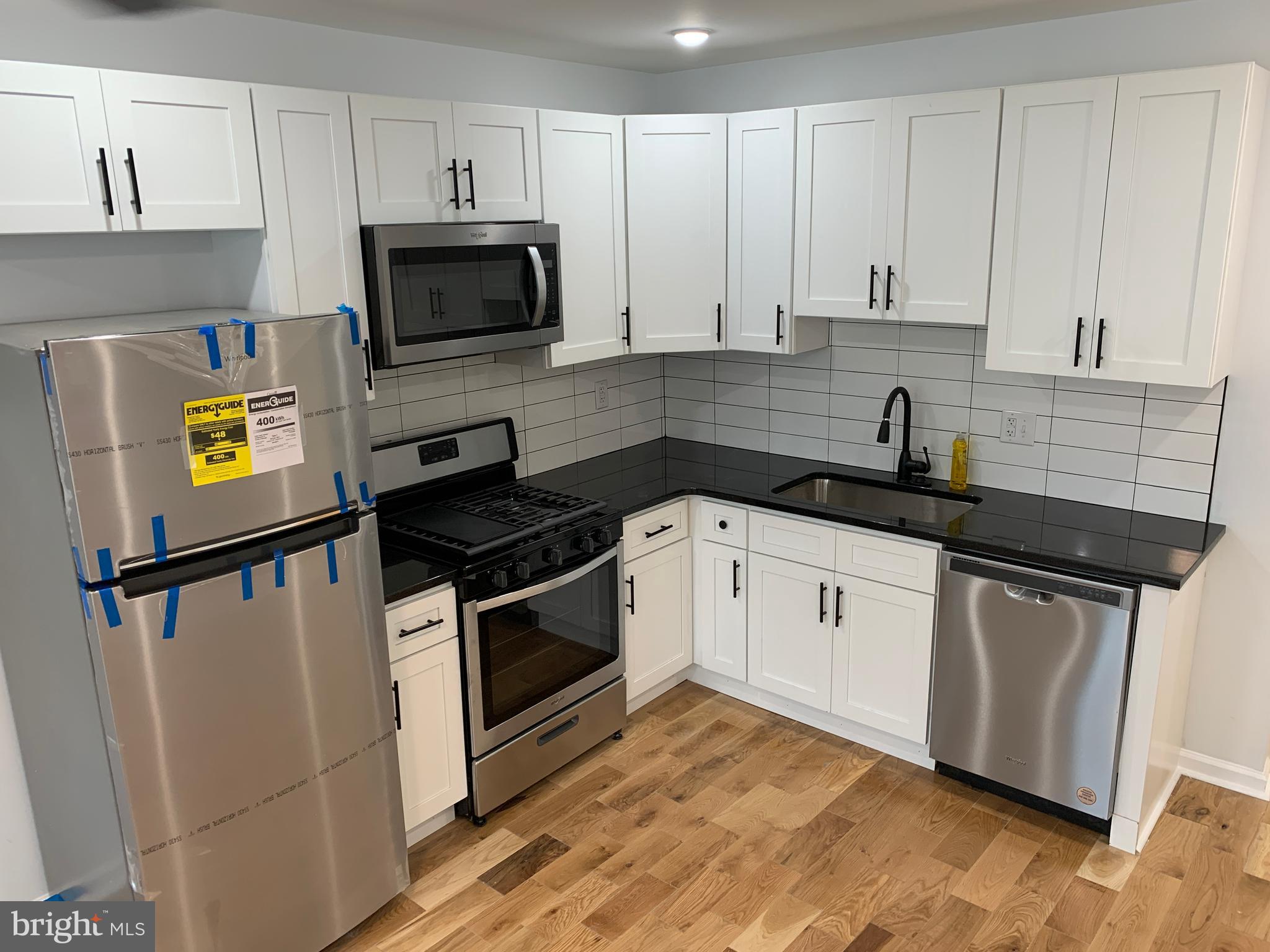 431 South 56th Street, Unit 1 Philadelphia, PA 19143 - Photo 8 of 29 a kitchen with granite countertop a sink a stove and cabinets