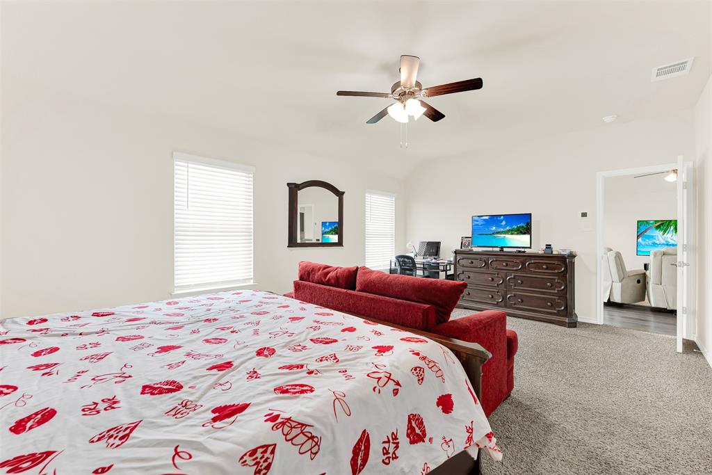 720 Willow View Way Princeton, TX 75407 - Photo 16 of 33 a bedroom with a bed and a chandelier