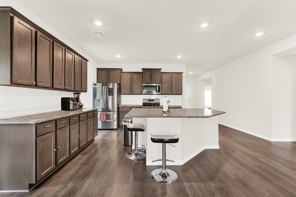 720 Willow View Way Princeton, TX 75407 - Photo 6 of 33 a kitchen with stainless steel appliances granite countertop a sink a stove a refrigerator cabinets and chairs
