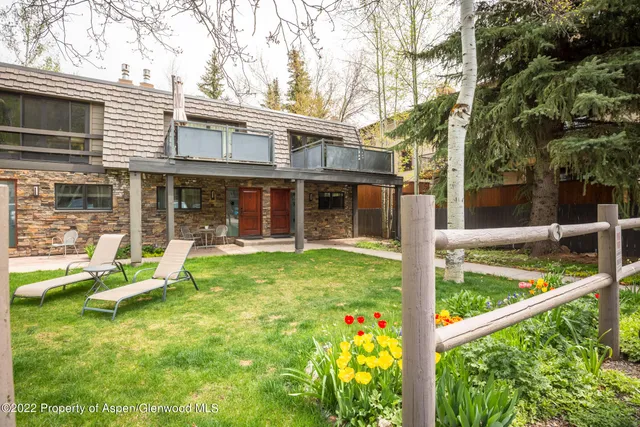 a view of a house with backyard and sitting area
