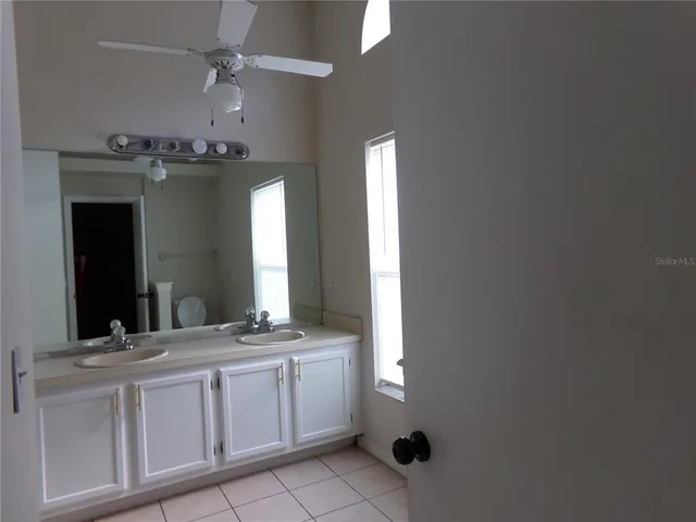 a bathroom with a double vanity sink and a mirror