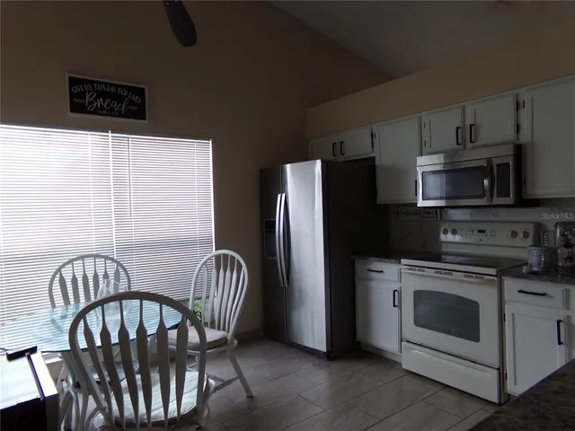 a kitchen with stainless steel appliances granite countertop a stove a refrigerator a microwave a sink and dishwasher