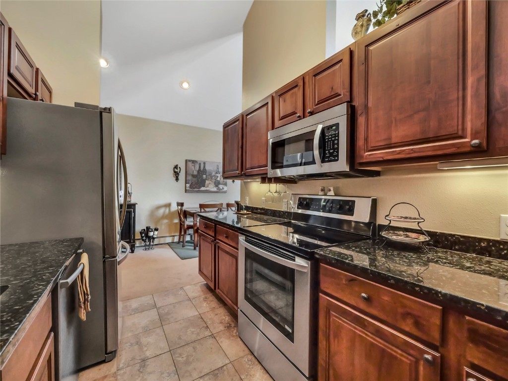 3710 Ryan Gulch Road, Unit 3710 Silverthorne, CO 80498 - Photo 19 of 50 a kitchen with stainless steel appliances granite countertop a stove microwave and sink