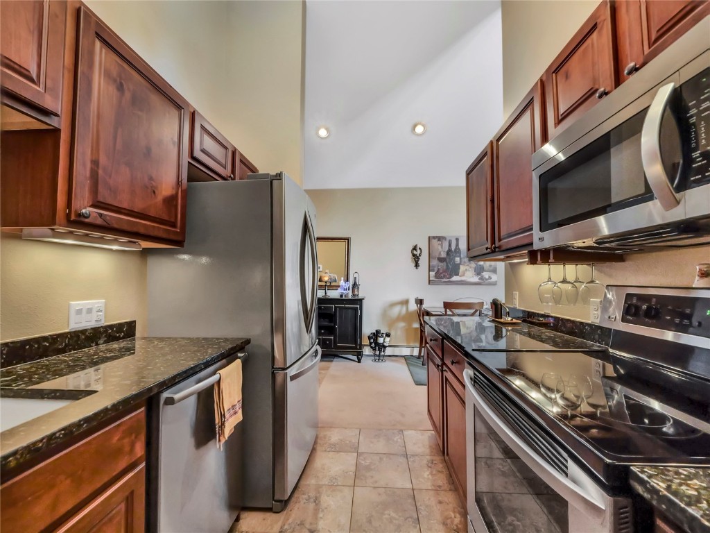 3710 Ryan Gulch Road, Unit 3710 Silverthorne, CO 80498 - Photo 20 of 50 a kitchen with stainless steel appliances granite countertop a stove sink microwave and cabinets