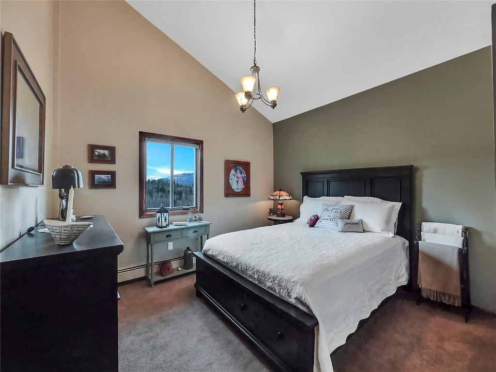 3710 Ryan Gulch Road, Unit 3710 Silverthorne, CO 80498 - Photo 22 of 50 a bedroom with a large bed and a chandelier
