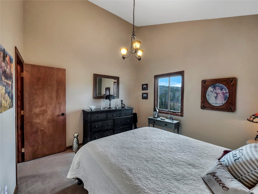 3710 Ryan Gulch Road, Unit 3710 Silverthorne, CO 80498 - Photo 23 of 50 a bedroom with a bed and a chandelier