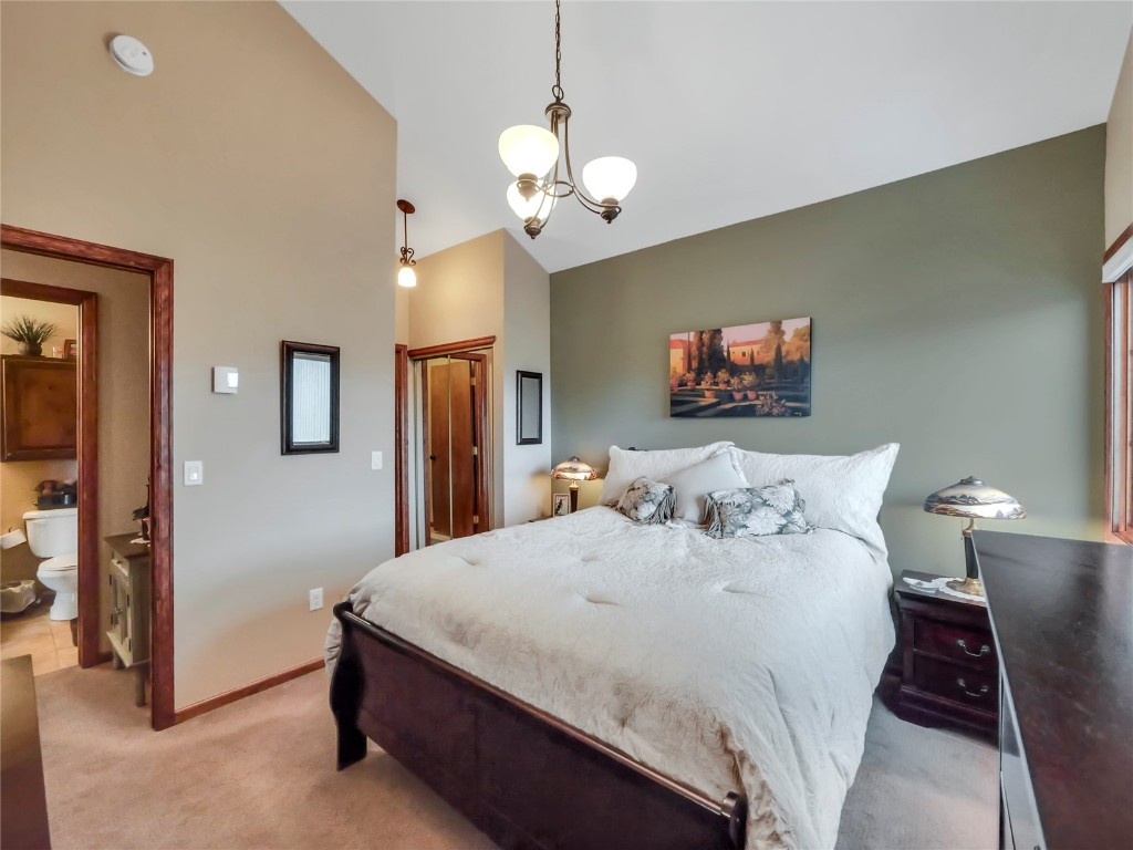 3710 Ryan Gulch Road, Unit 3710 Silverthorne, CO 80498 - Photo 28 of 50 a spacious bedroom with a bed and a chandelier