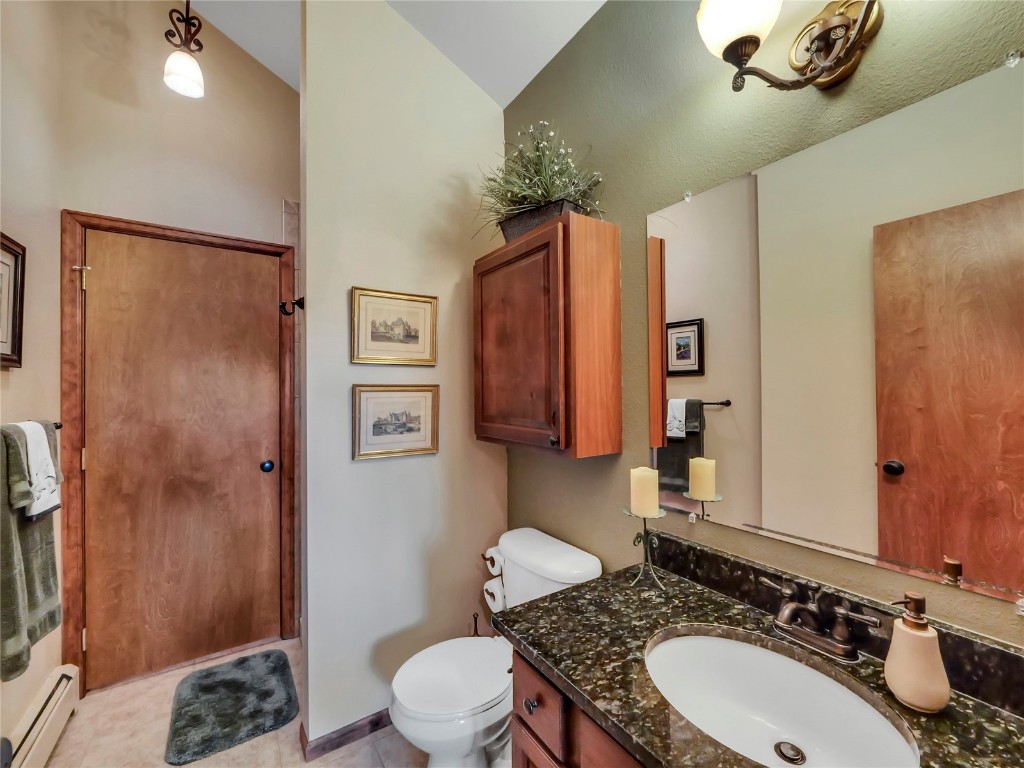 3710 Ryan Gulch Road, Unit 3710 Silverthorne, CO 80498 - Photo 34 of 50 a bathroom with a granite countertop sink toilet a mirror a vanity and shower