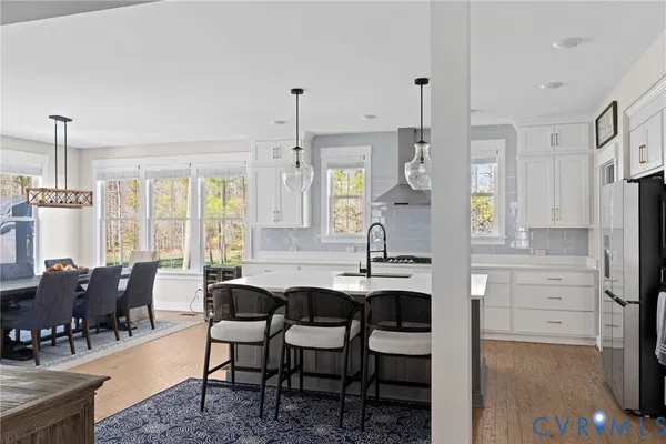 a kitchen with stainless steel appliances a stove a white cabinet and a granite countertops with wooden floor