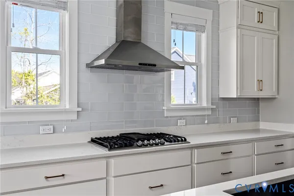 a kitchen with stainless steel appliances kitchen island granite countertop a table chairs sink and cabinets