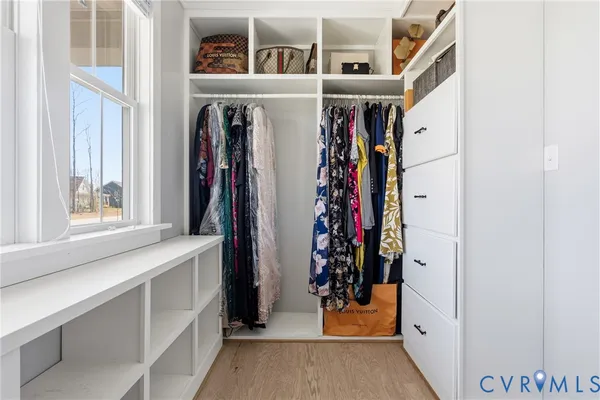 a view of a bedroom with wooden floor and window