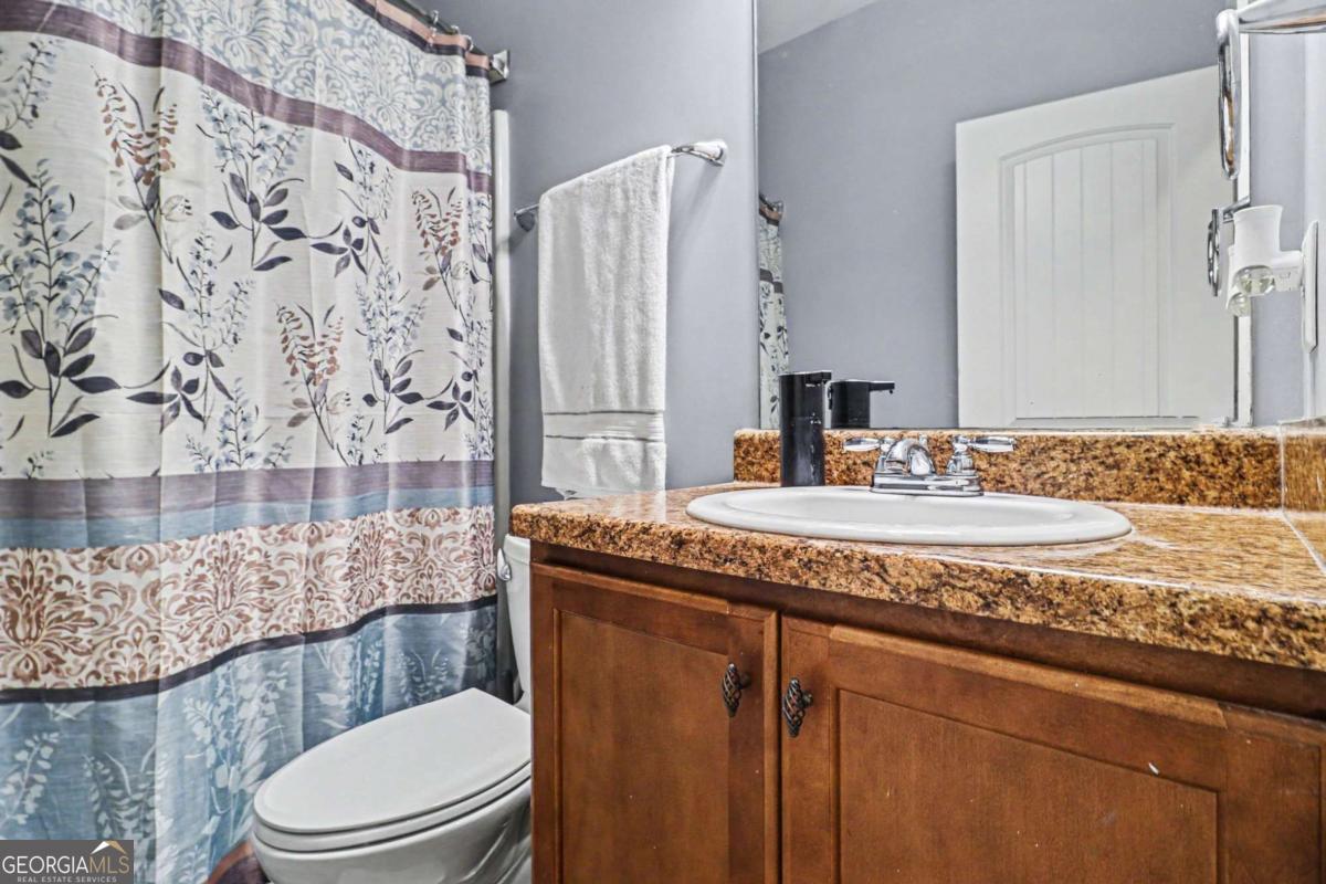 207 George Wynn Road Palmetto, GA 30268 - Photo 29 of 32 a bathroom with a granite countertop toilet sink and mirror