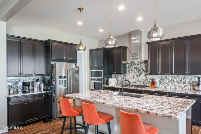 a kitchen with stainless steel appliances granite countertop wooden cabinets a stove a sink and a refrigerator