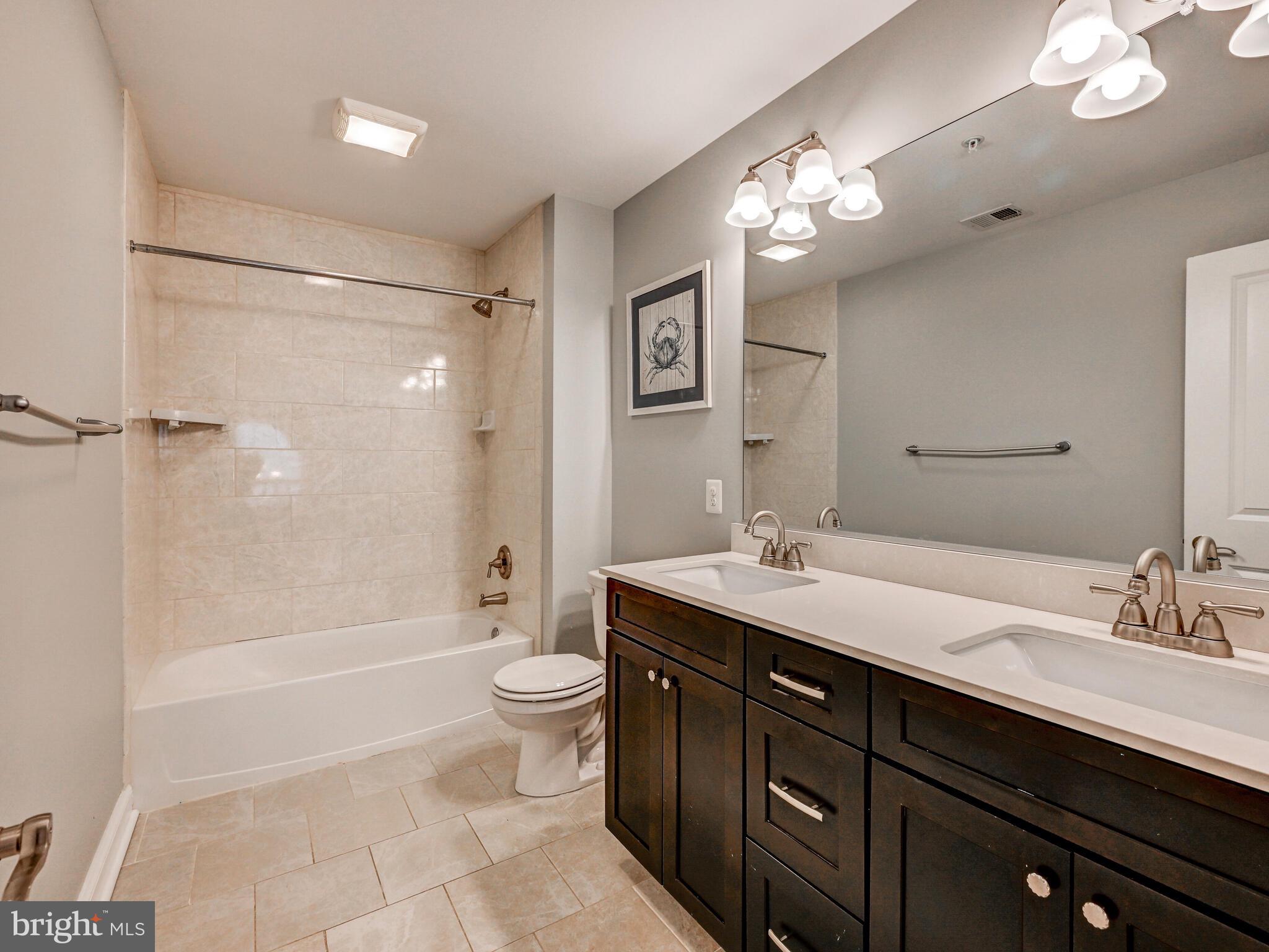 11707 Manor Road Glen Arm, MD 21057 - Photo 30 of 43 a bathroom with a sink a toilet a mirror a bathtub and shower