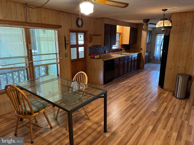 a kitchen with stainless steel appliances granite countertop a stove top oven a dining table and chairs with wooden floor