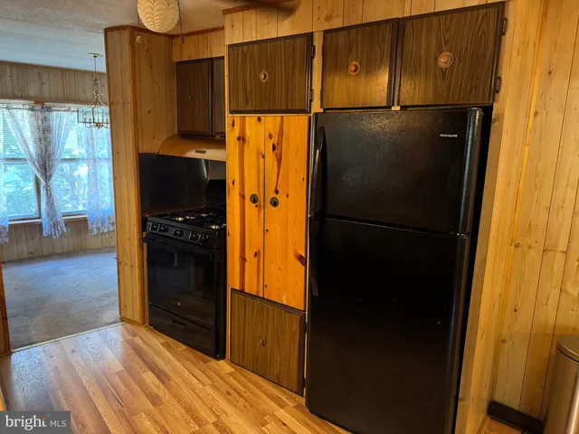 a kitchen with a refrigerator and a stove top oven