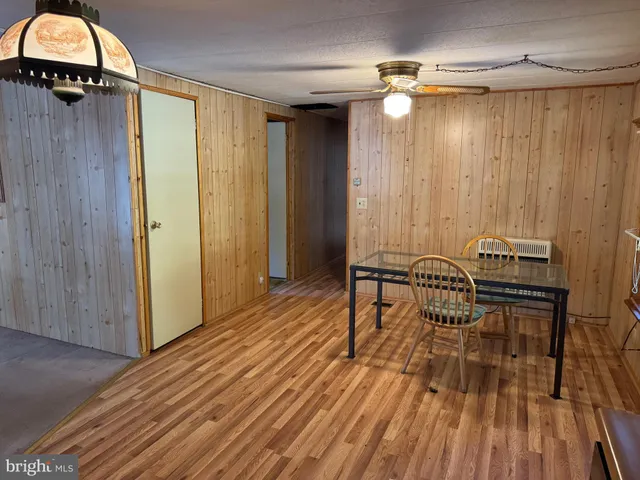 a view of a room with wooden floor table and chairs