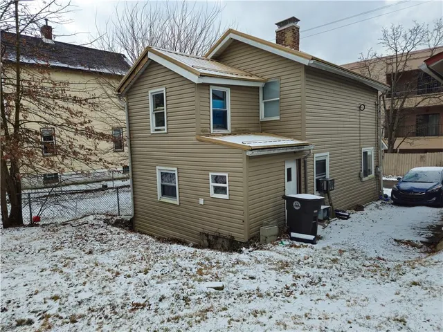 a view of a house with a yard and wooden fence