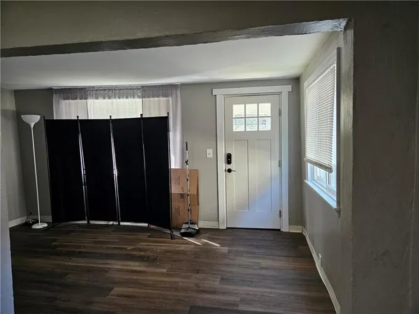 an empty room with wooden floor and a window