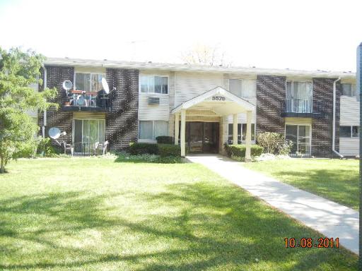 9575 Terrace Place, Unit 1G Des Plaines, IL 60016 - Photo 1 of 1 a front view of a house with a yard